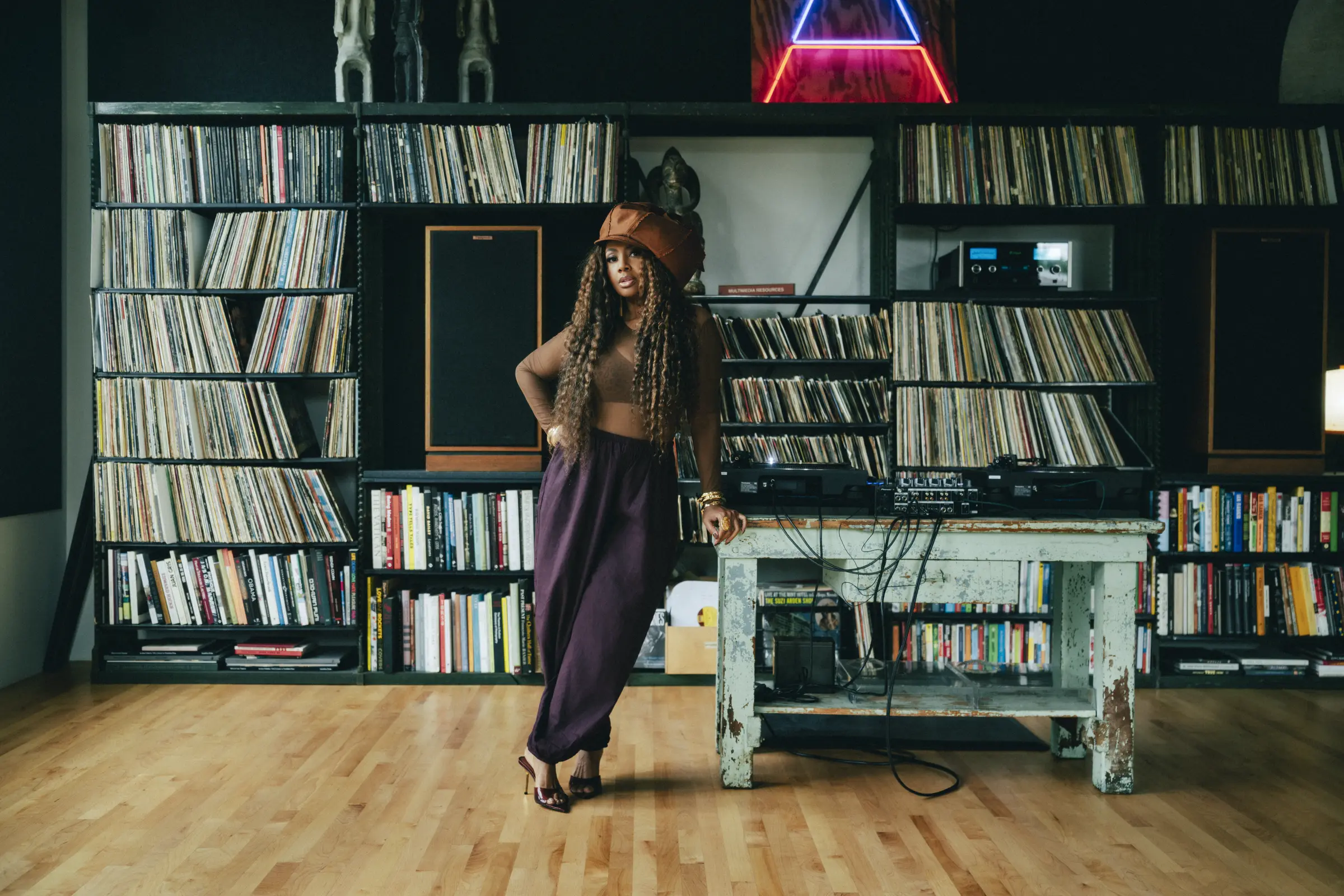 Lalah Hathaway standing among records in a listening room.